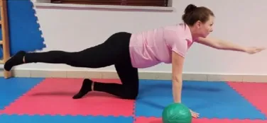 Tehotná žena cvičí na podložke s overballom